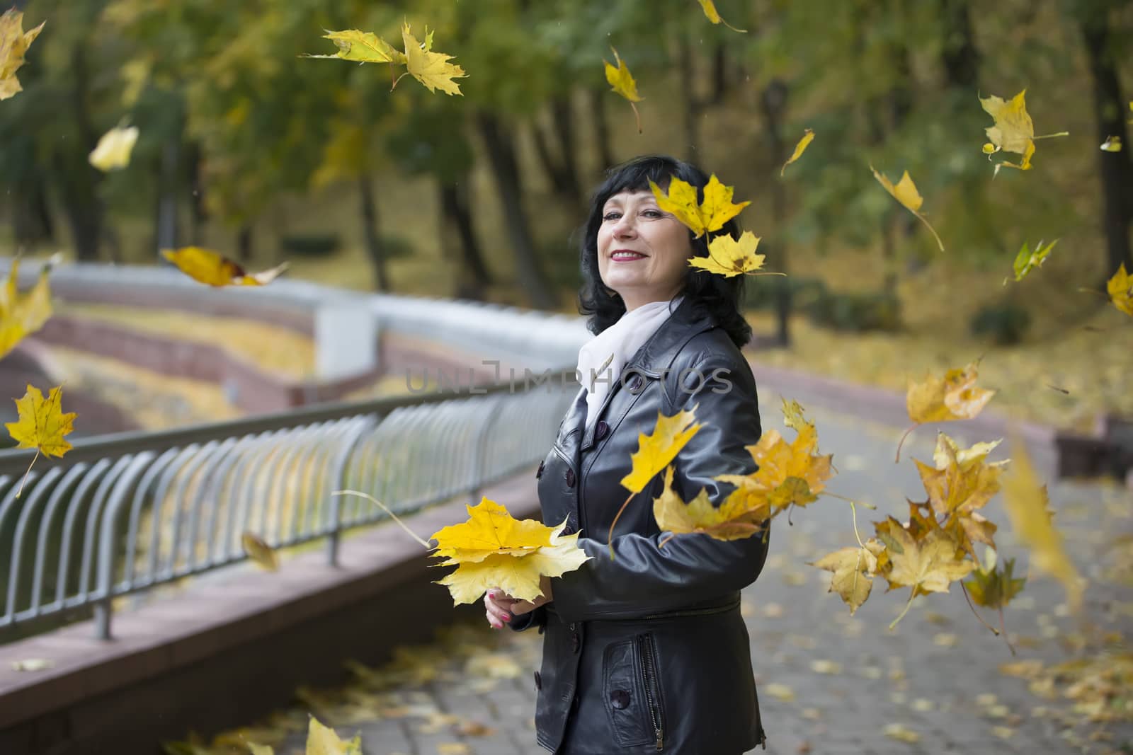 Mature woman in autumn leaves