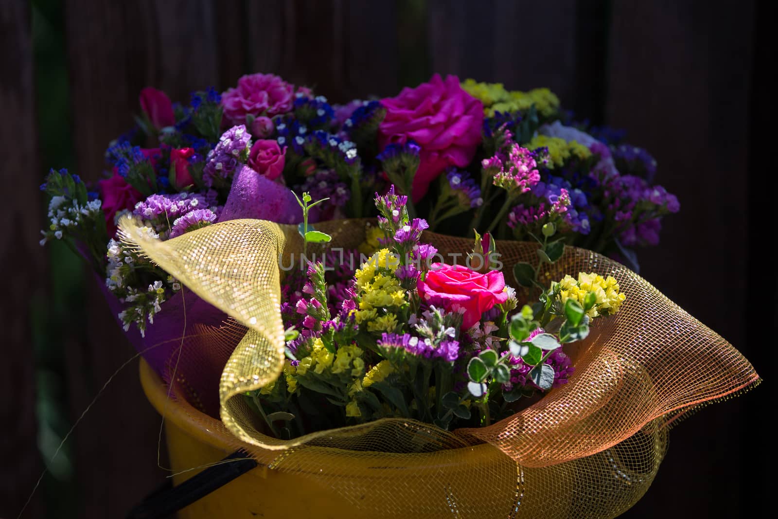 A bouquet of flowers in a plastic bucket. Buetnatural flowers