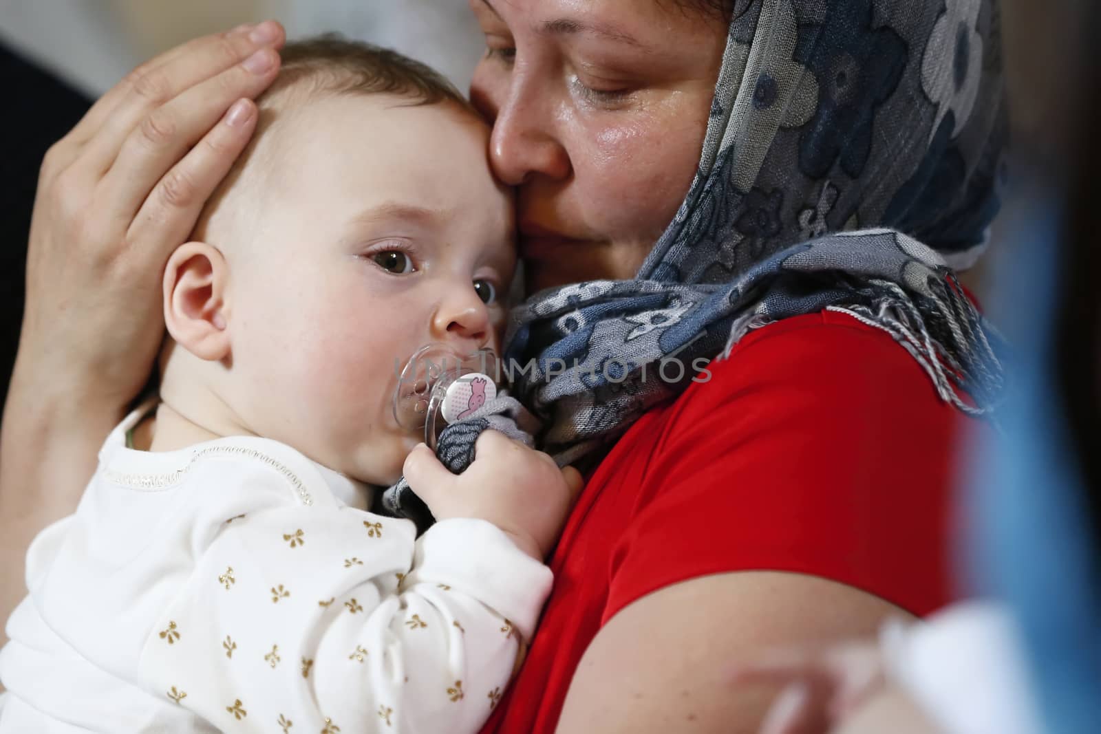 Belarus, the city of Gomel, St. Nicholas Monastery.June 18, 2016.Baptism of the Child.The mother holds the child in her arms.Mother pities her son. Infant and mother