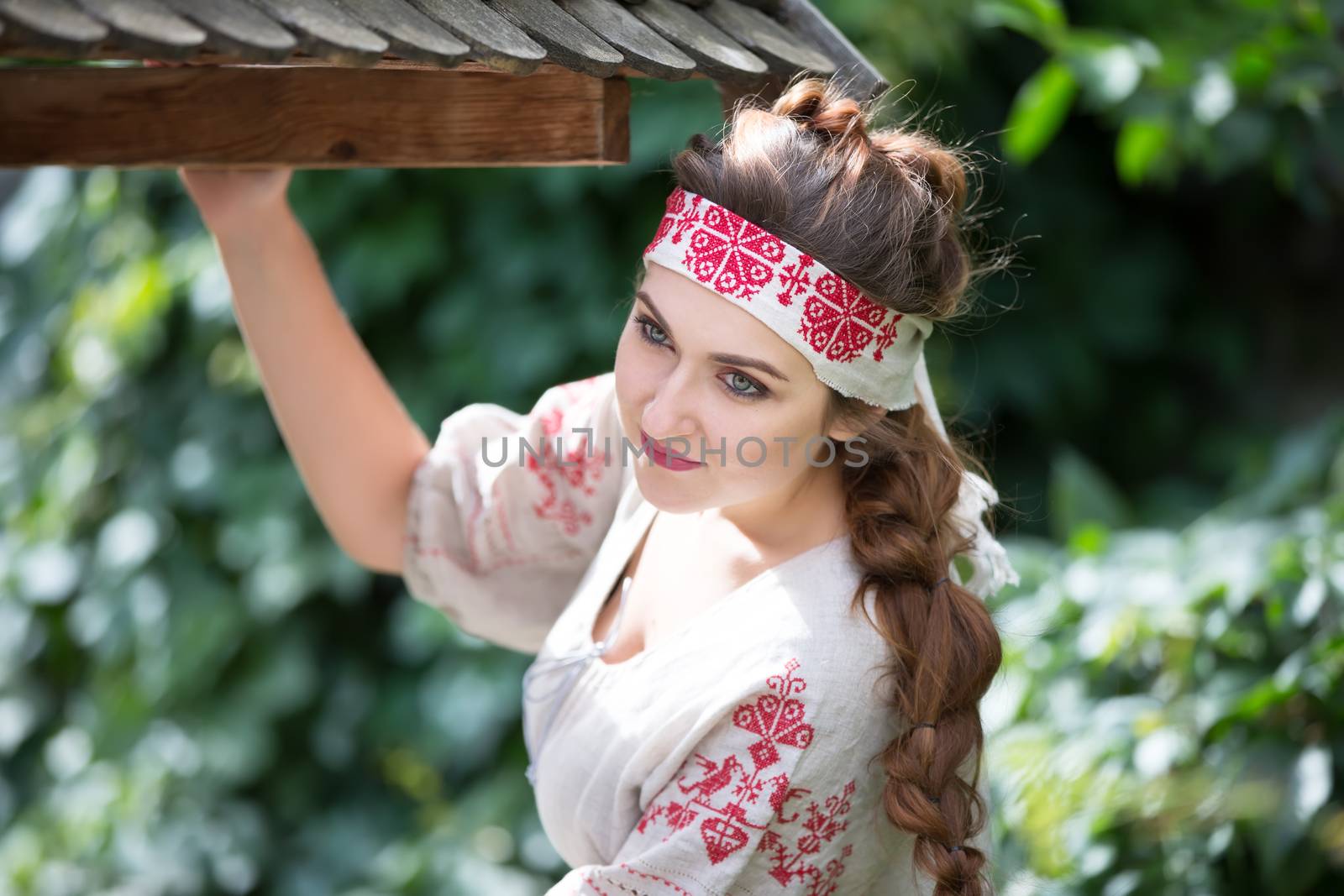 Russia, Moscow, August 27, 2017, the international festival of photography.Russian girl in national dress at a wooden well