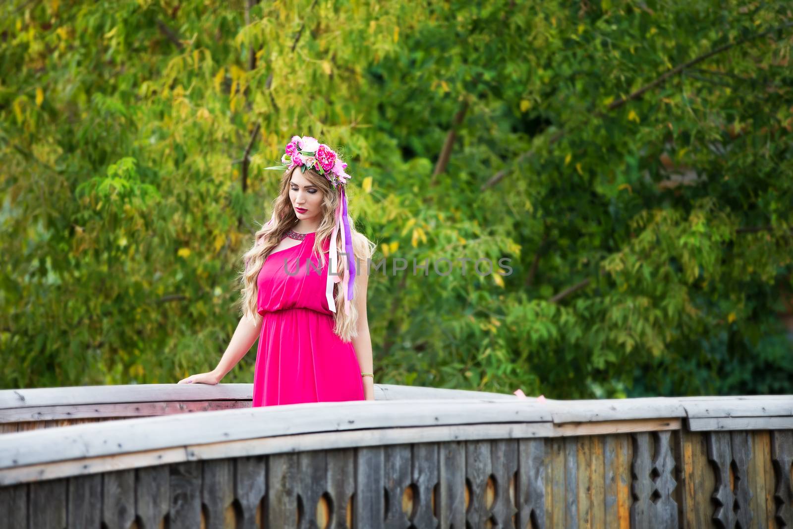 Russia, Moscow, Izmaylovsky Park, August 27, 2017. International Photo Festival.A girl with a wreath on her head is walking on the bridge. A girl with a wreath on her head in an ethnic manner.