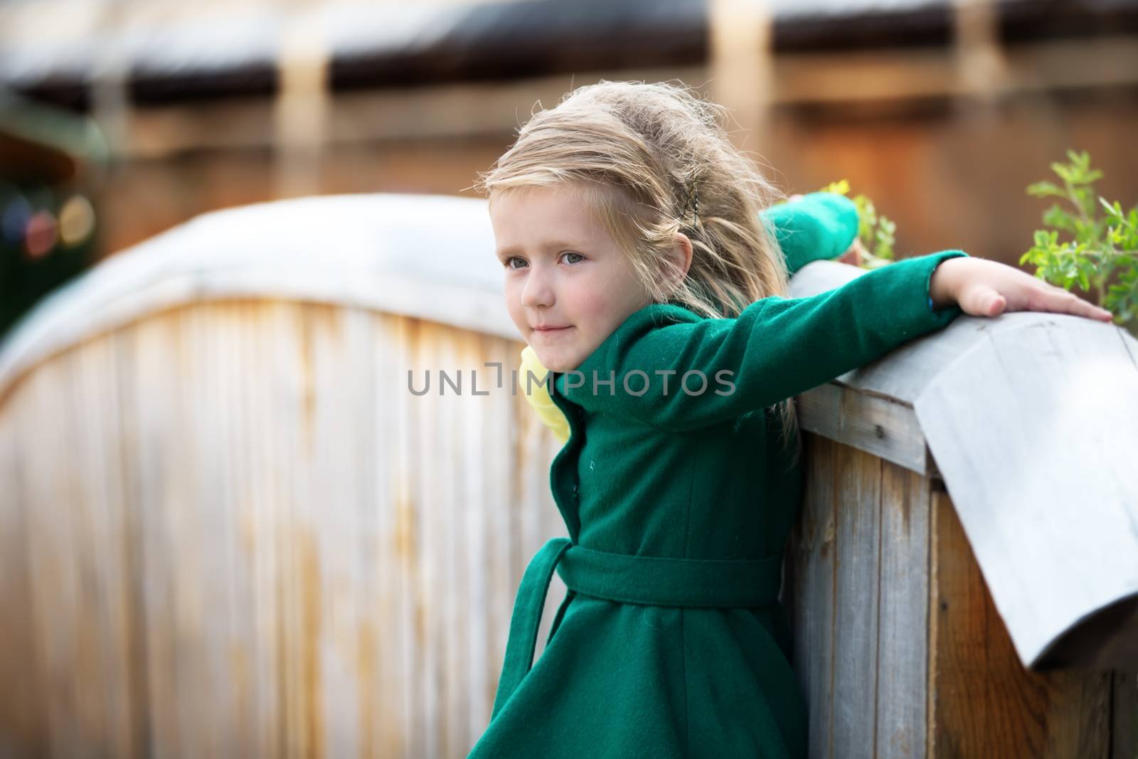 Russia, Moscow, Izmaylovsky Park, August 27, 2017. International Photo Festival.Little girl on a walk in a coat near the fence. Beautiful little girl