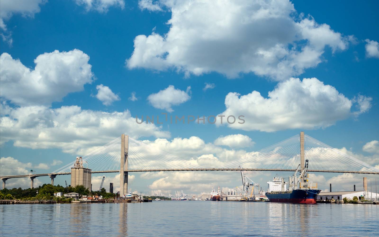 Freight industry at busy harbor on the Savannah River with suspension bridge