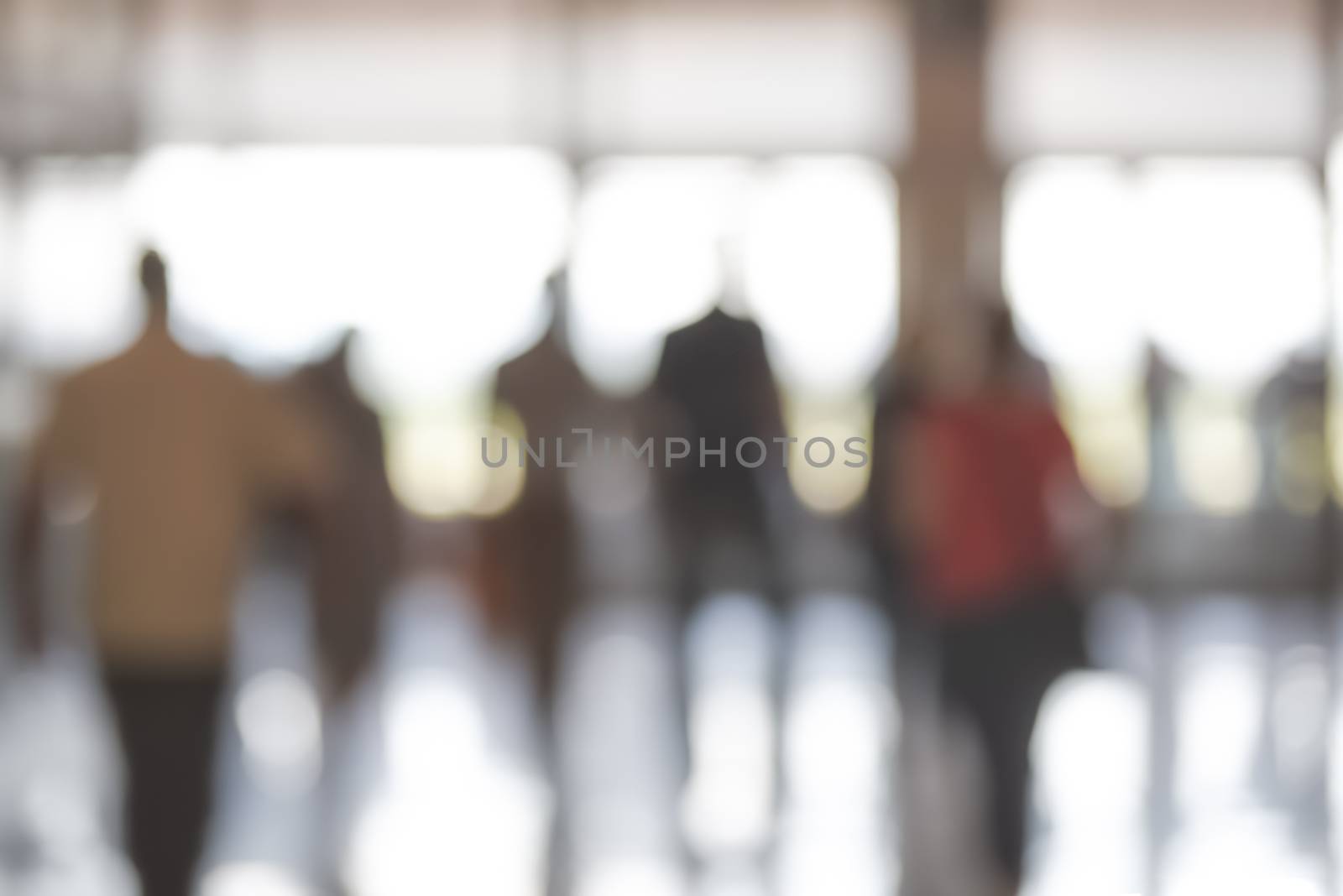 Business corporation background - blurred corridor in a corporate office or airport with people in motion