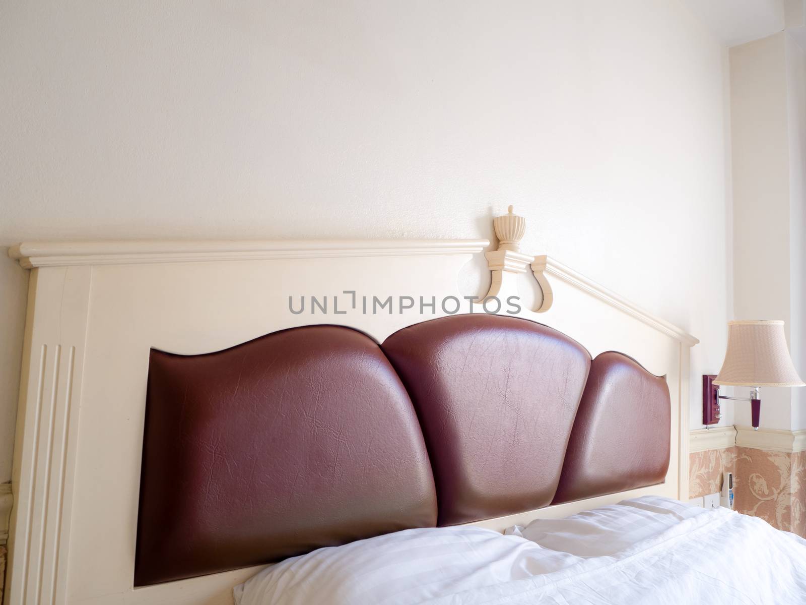 bedroom interior with pillows and reading lamp on bedside table