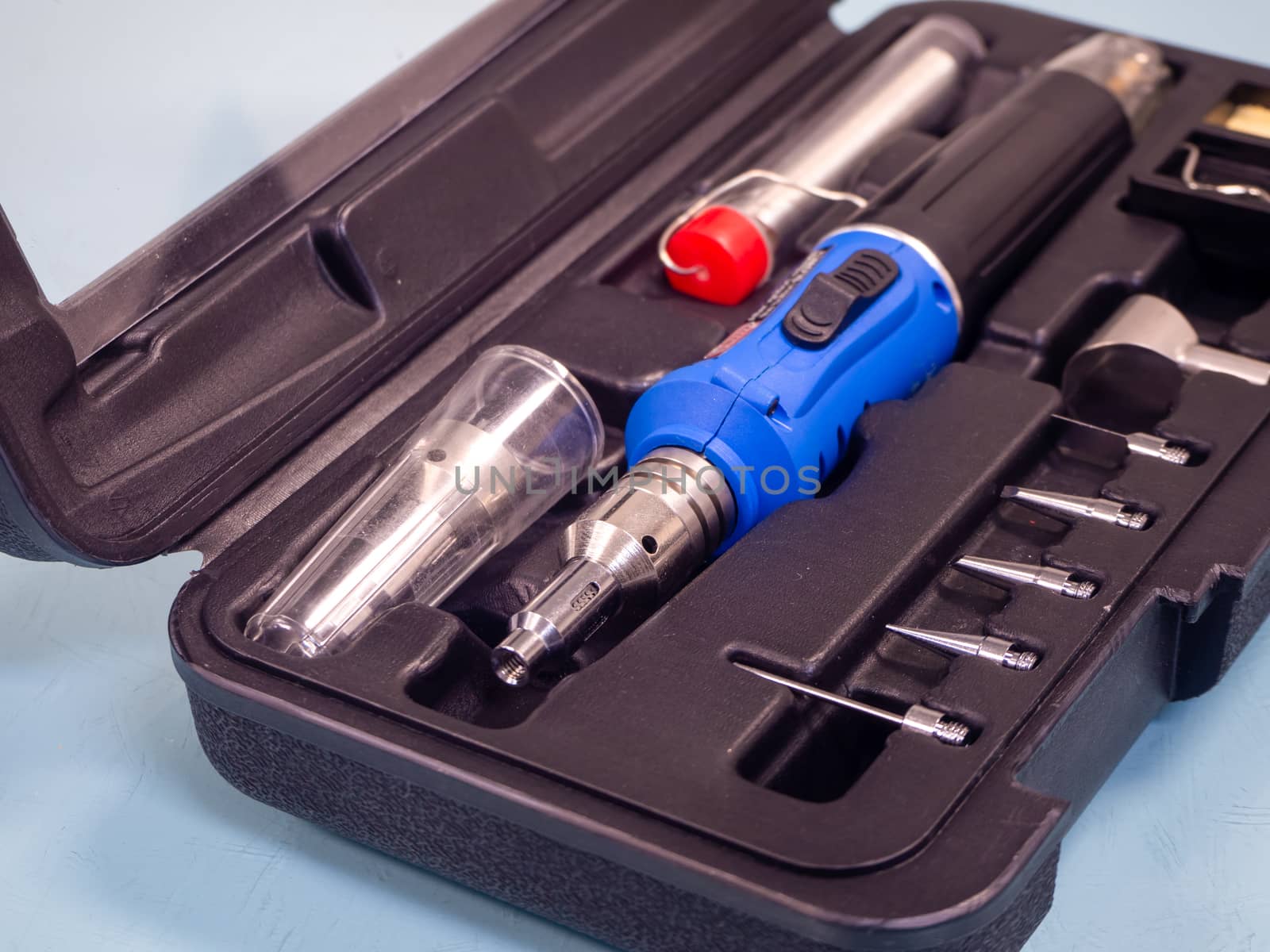 Gas soldering iron in black box isolated on white background.