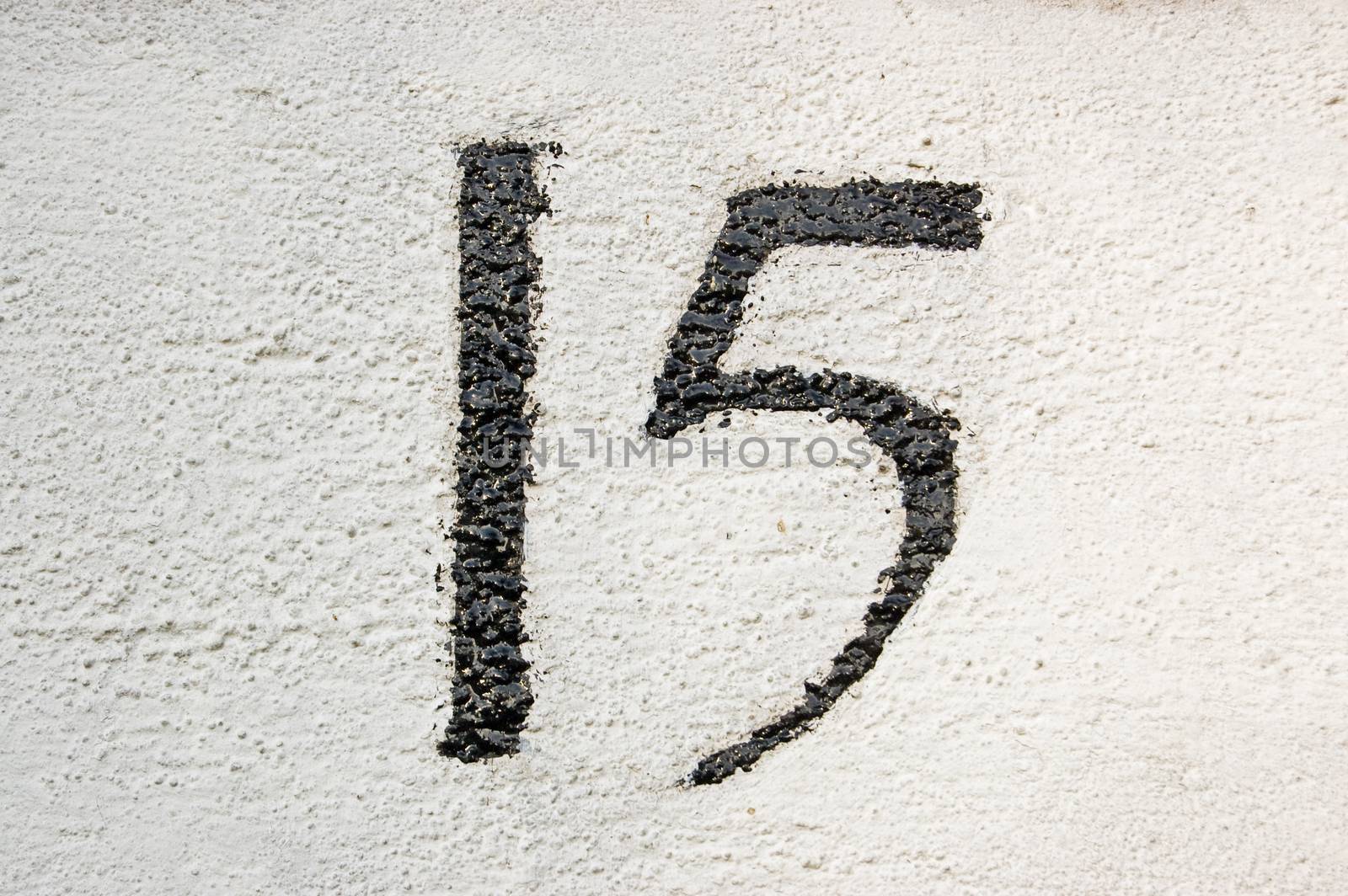 Number fifteen painted on the wall outside a house in London.