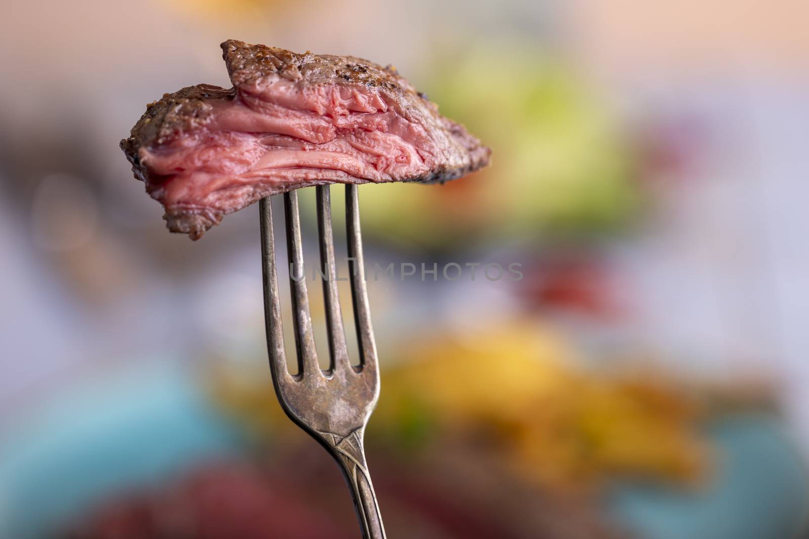 slice of steak on a fork by bernjuer