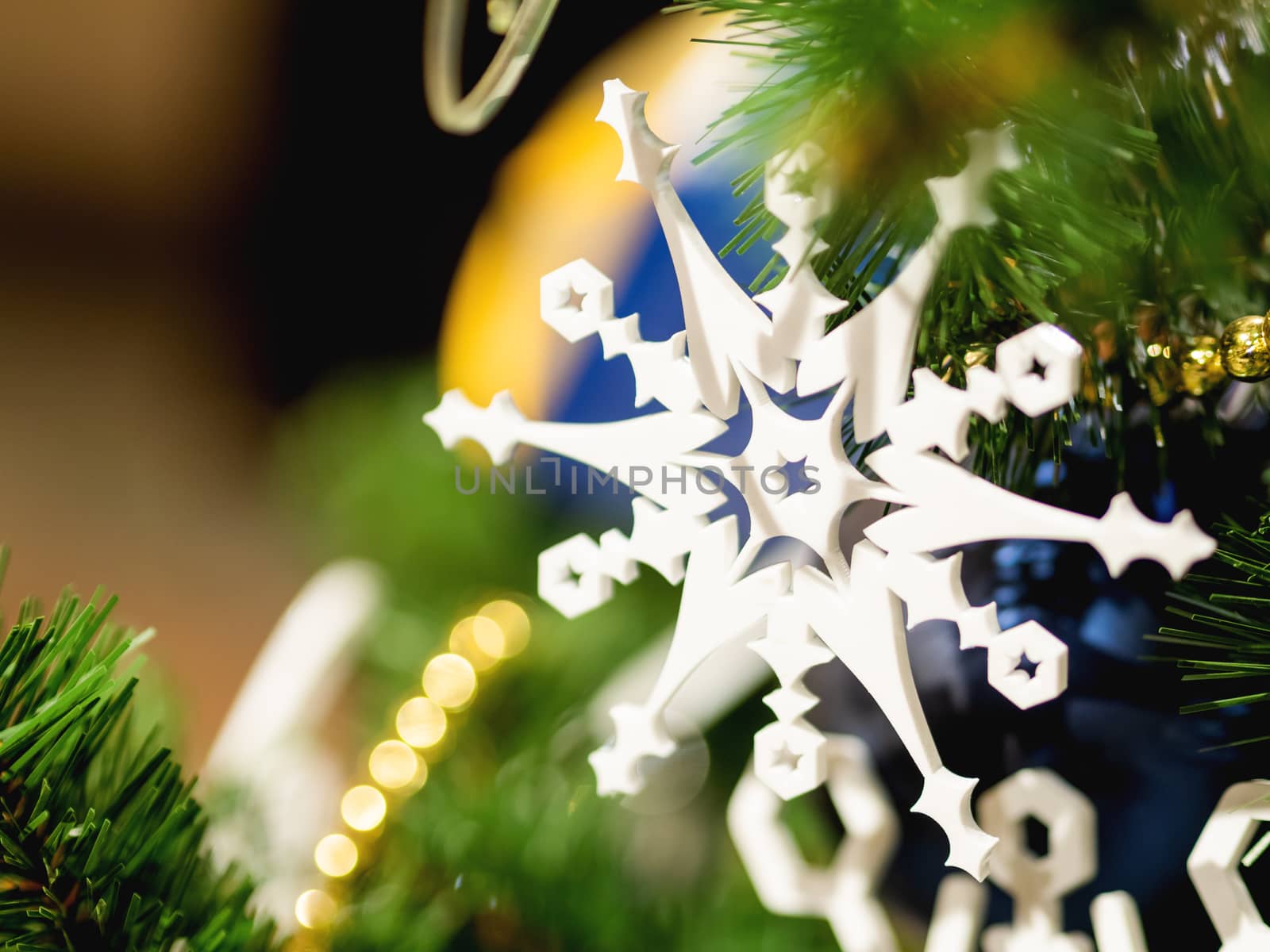 Christmas and New Year rustic decorations - wooden snowflakes on Christmas tree with light bulbs.