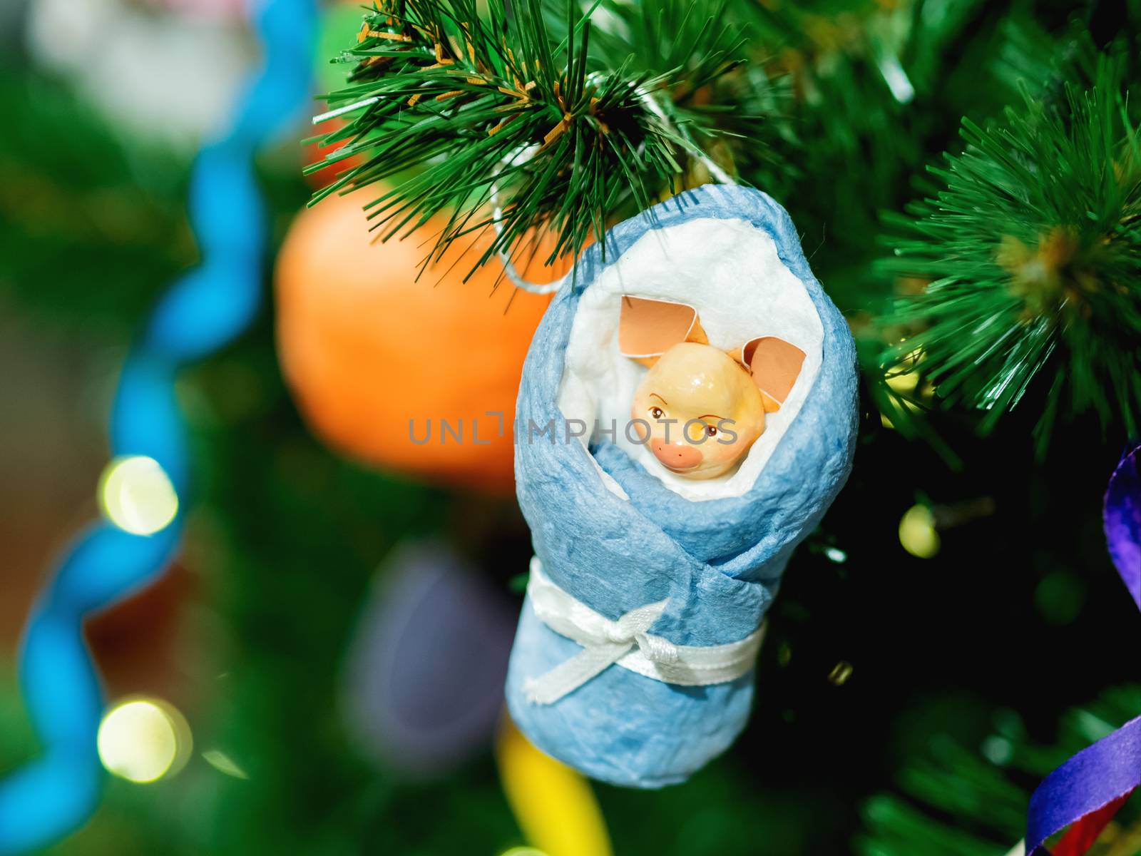 Old fashioned New Year decoration for Christmas tree. Figure of piglet in blanket made of cellulose wadding. Symbol of 2019 year.