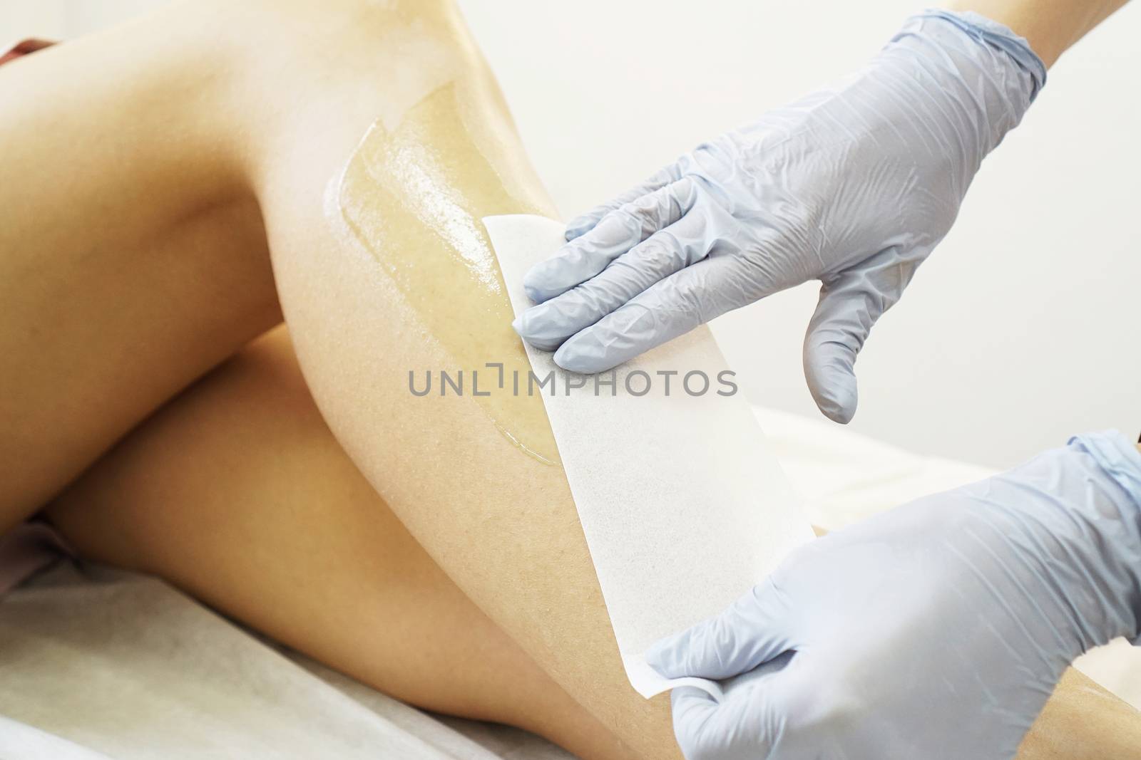 Hair removal from beautiful female legs. Waxing in a beauty salon by natali_brill