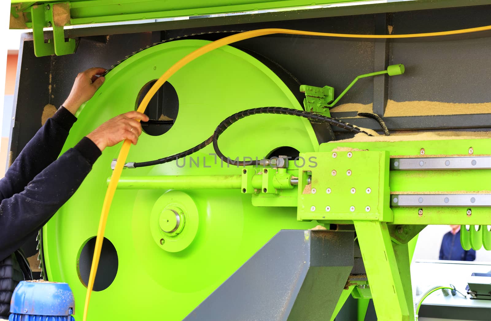 Woodworking, worker replaces a band saw at a modern automatic sawmill.