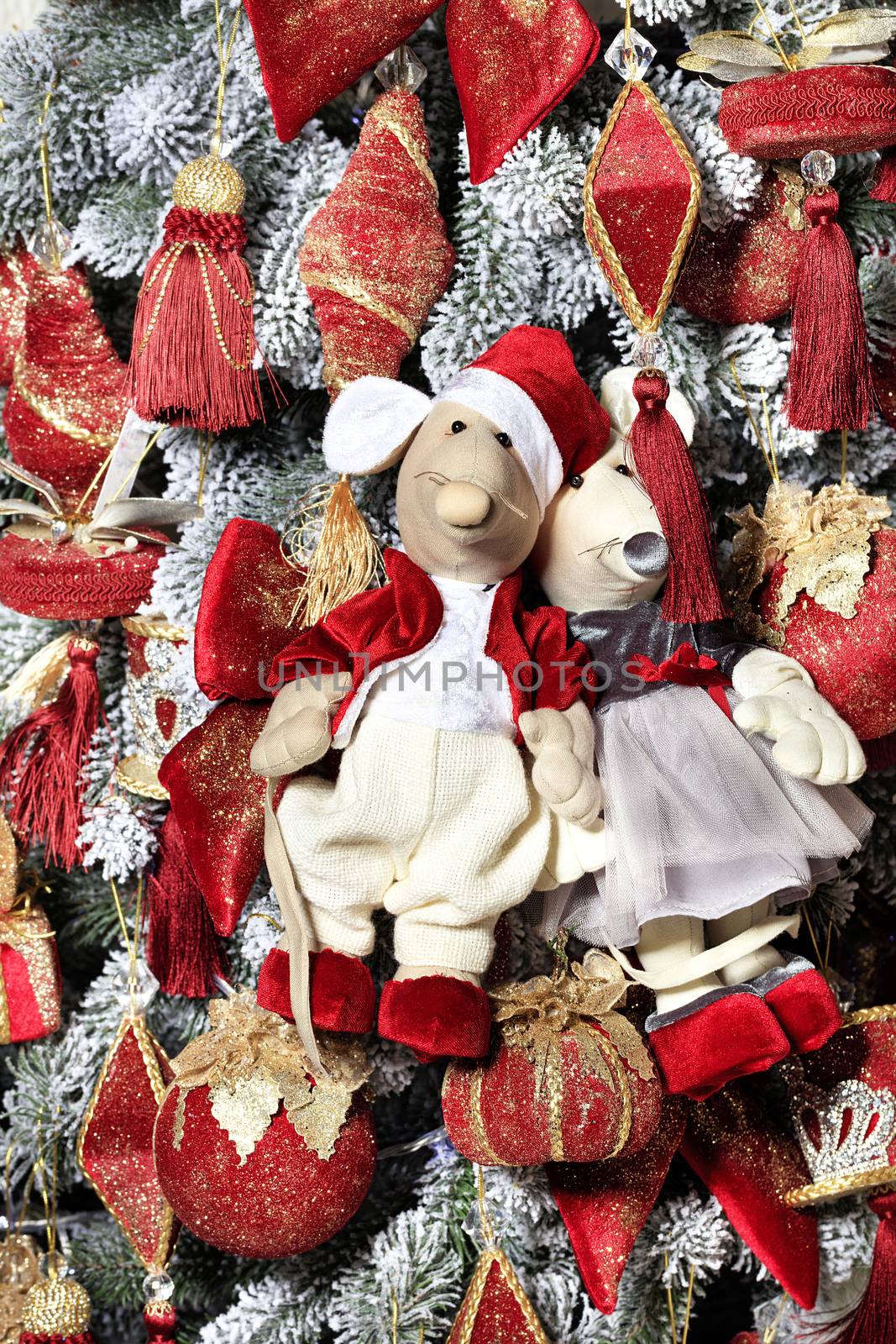 Pair of decorative toy mice dressed in a red frock coat and elegant dress are hanging on a Christmas tree on the eve of the rat year. New Year celebration concept, 2020 symbol,
