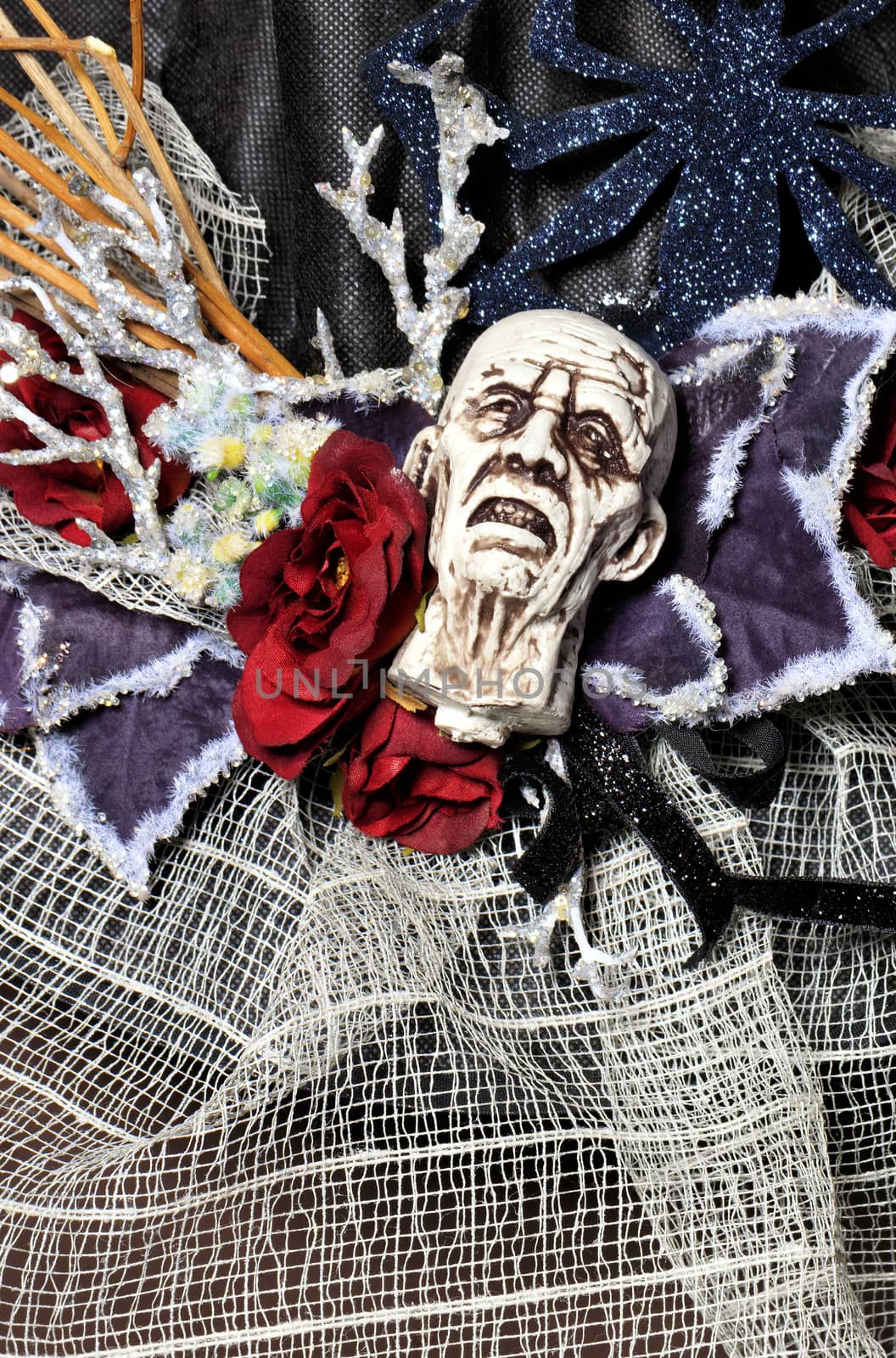 Decorative white tormented head, skull, spider, web, red flower and various accessories in a single composition for the celebration of Halloween, copy space image.