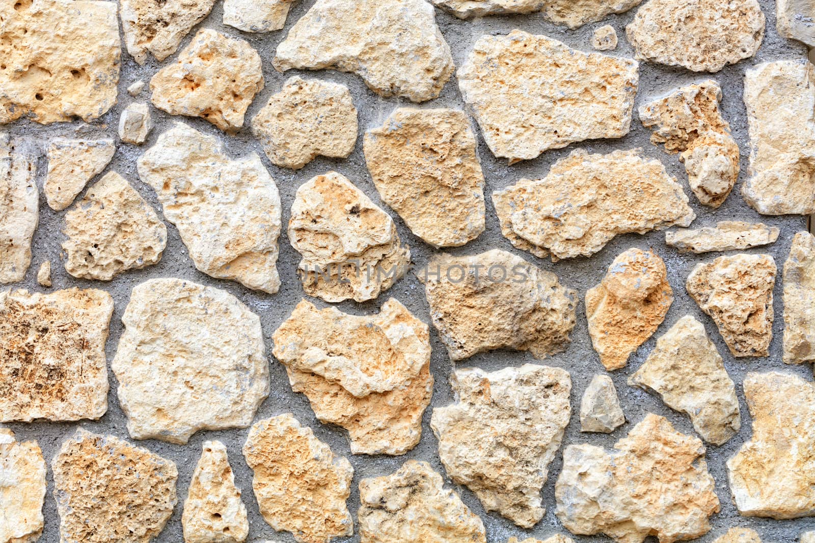 Texture of a stone wall extruded from a large cobblestone of a shell rock, closeup. by Sergii