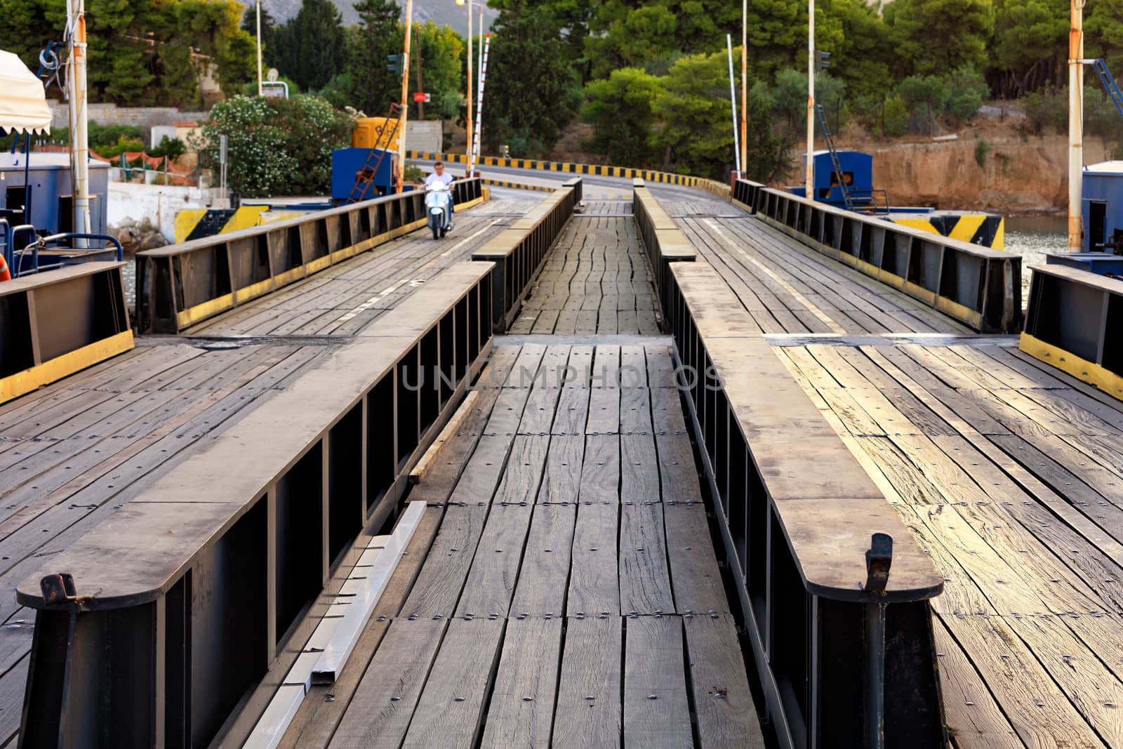 Automobile and pedestrian bridge over the Corinth Canal in Greece in the soft rays of morning light. The bridge is flooded when ships and boats pass through the canal, an image with copy space.