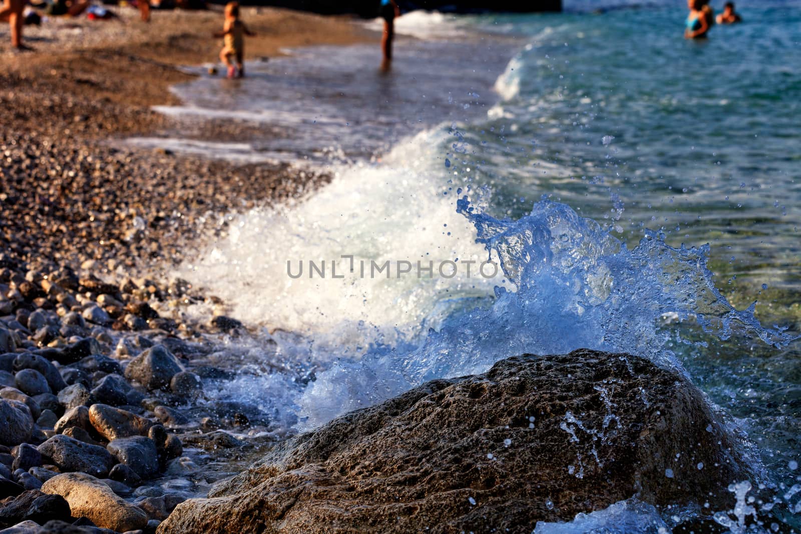 Splash of the sea wave on a large boulder on the sea beach. by Sergii