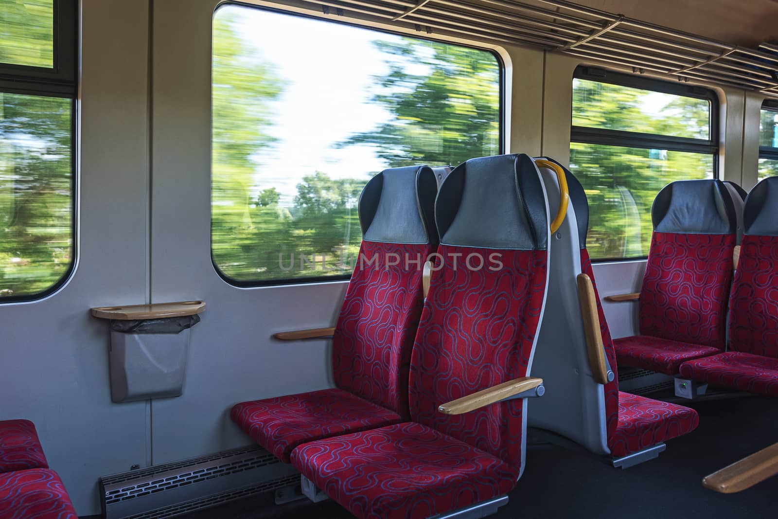 Interior view of an empty passenger wagon in a moving train.