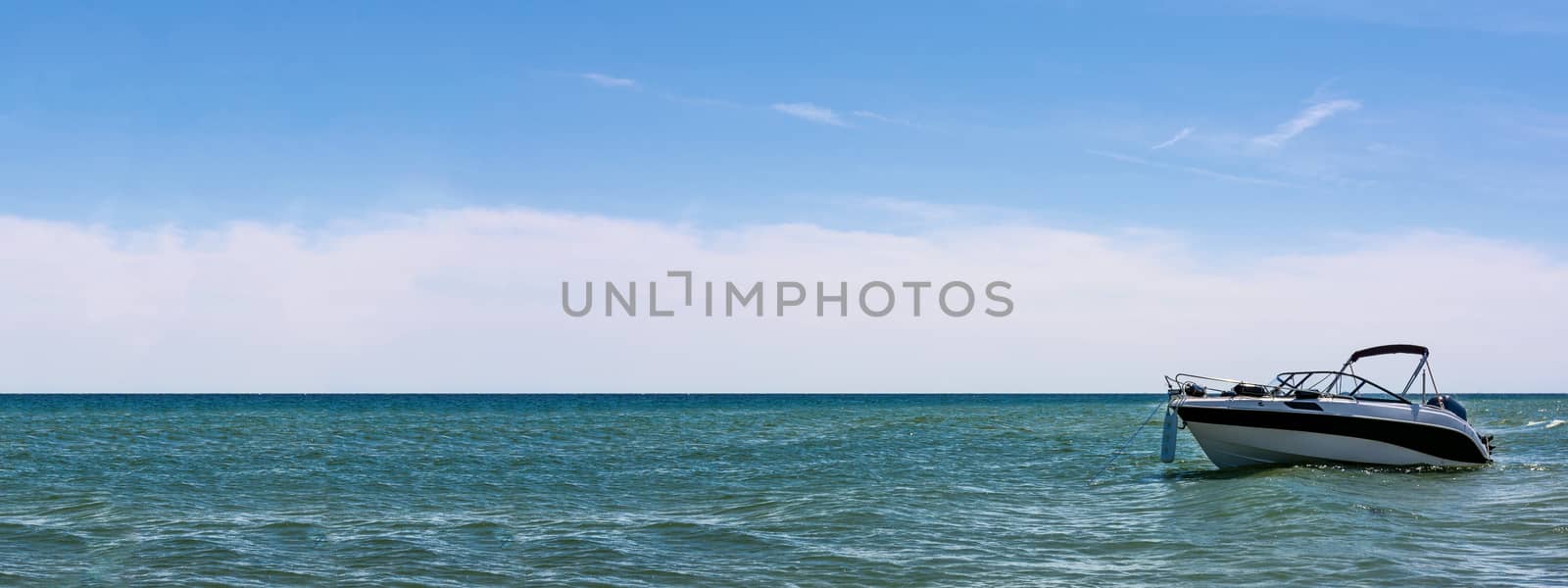 Marine vacation banner - empty white speed boat on seaside on blue sky background