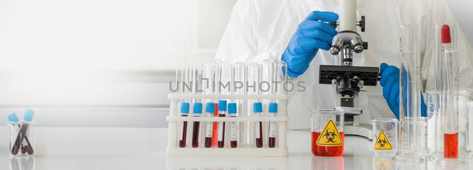 Researchers use microscopes to look at blood samples of infected people.
Coronavirus disease 2019 (COVID-19)  testing process in a laboratory preventing the spread of viral research.