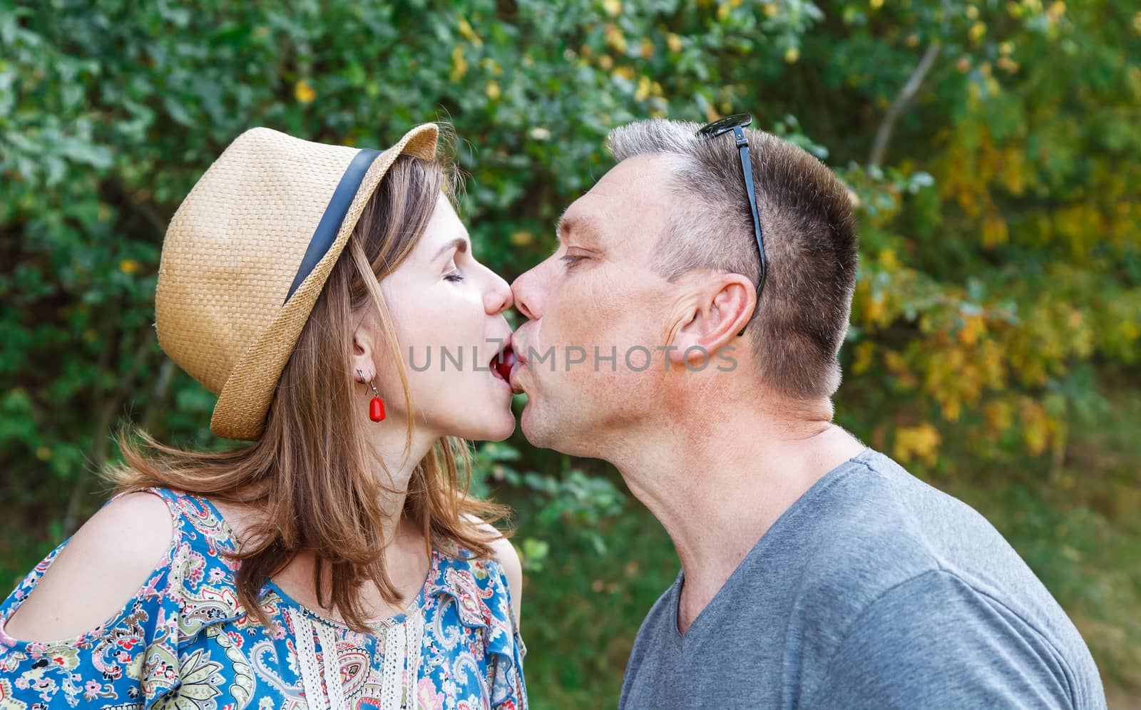 pair of lovers kissing in the forest on sunny summer day