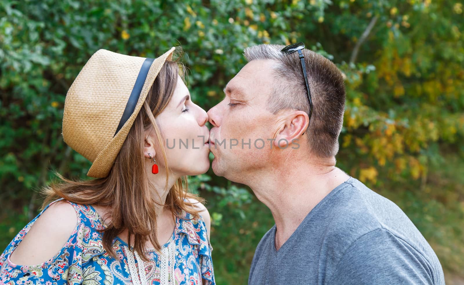 pair of lovers kissing in the forest on sunny summer day