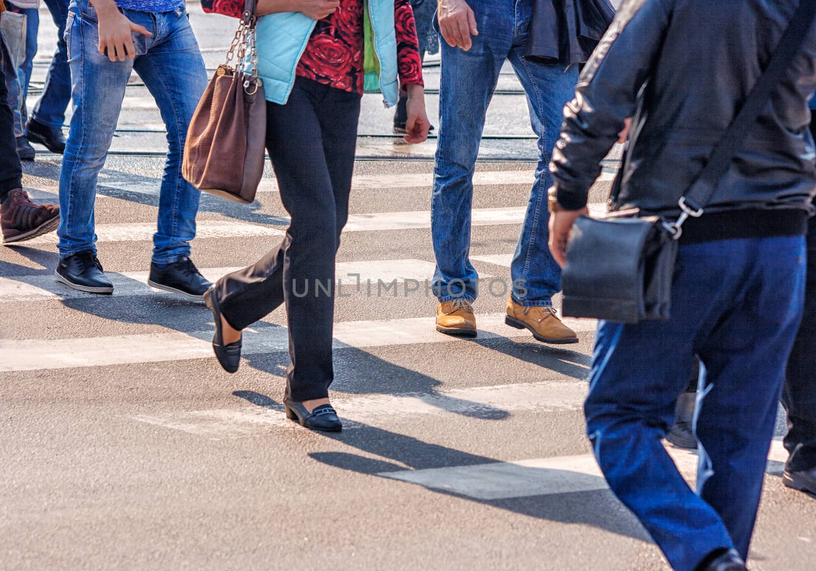 crossroad with walking pedestrians on sunny spring day