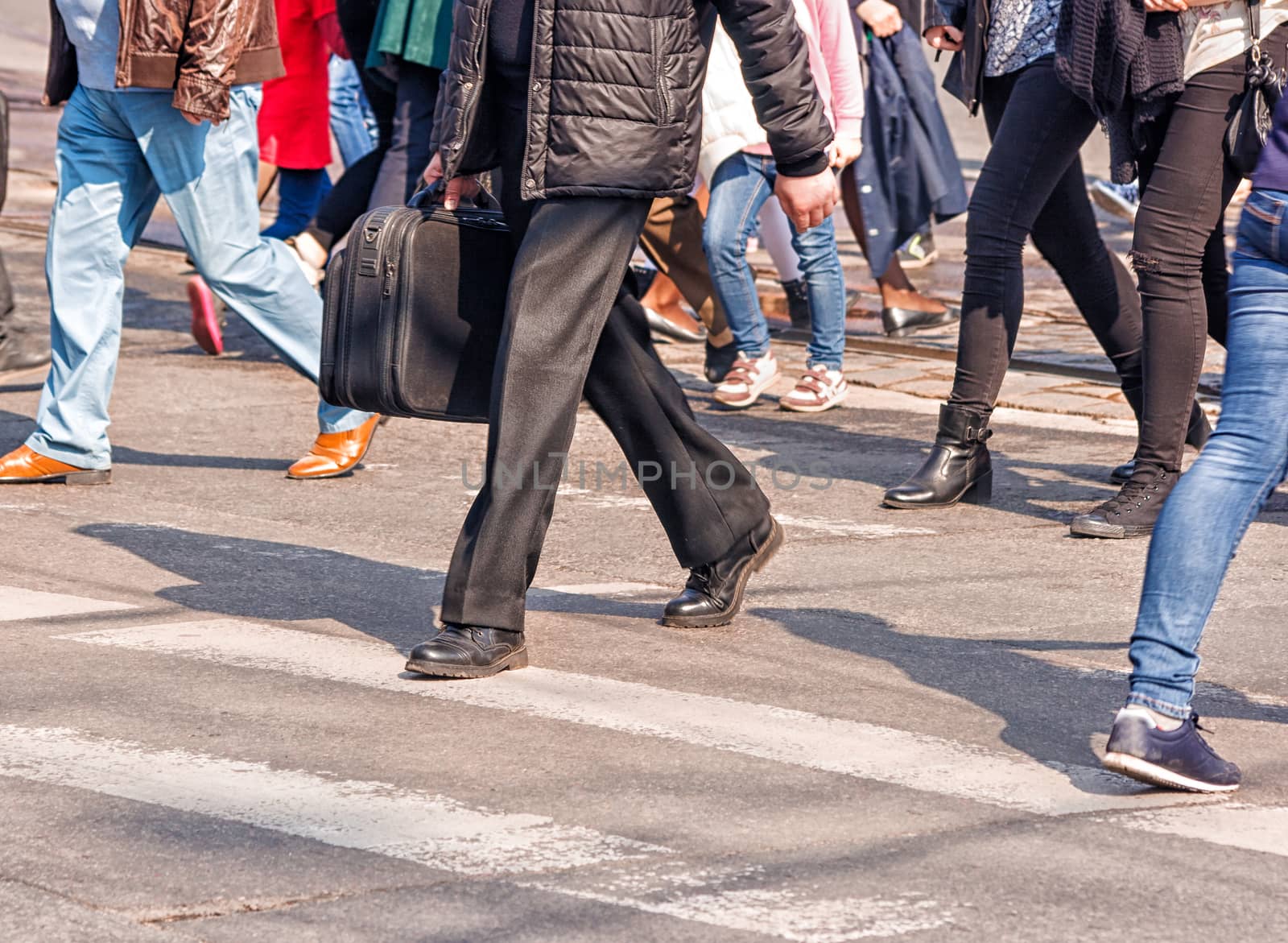 crossroad with walking pedestrians on sunny spring day