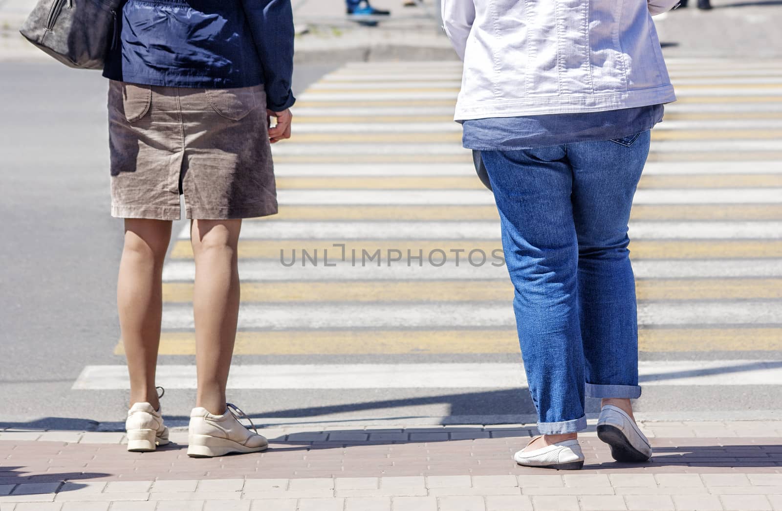 women is waiting to cross the road on sunny summer day