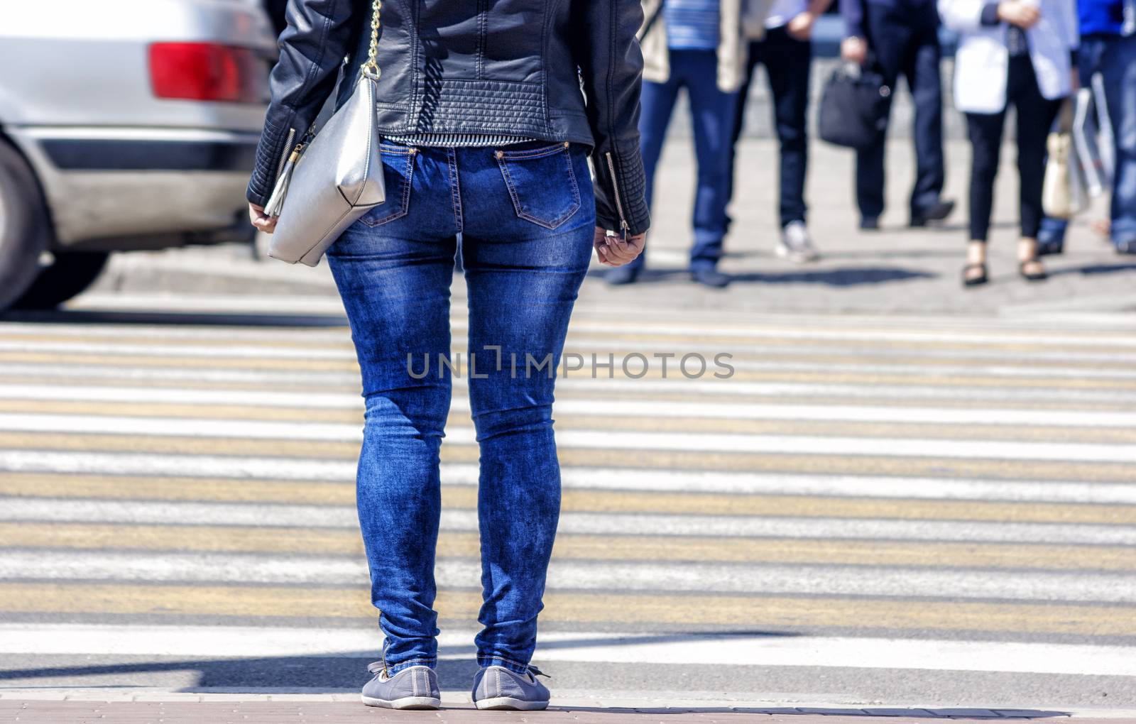 waiting woman at the pedestrian crossing and car traffic