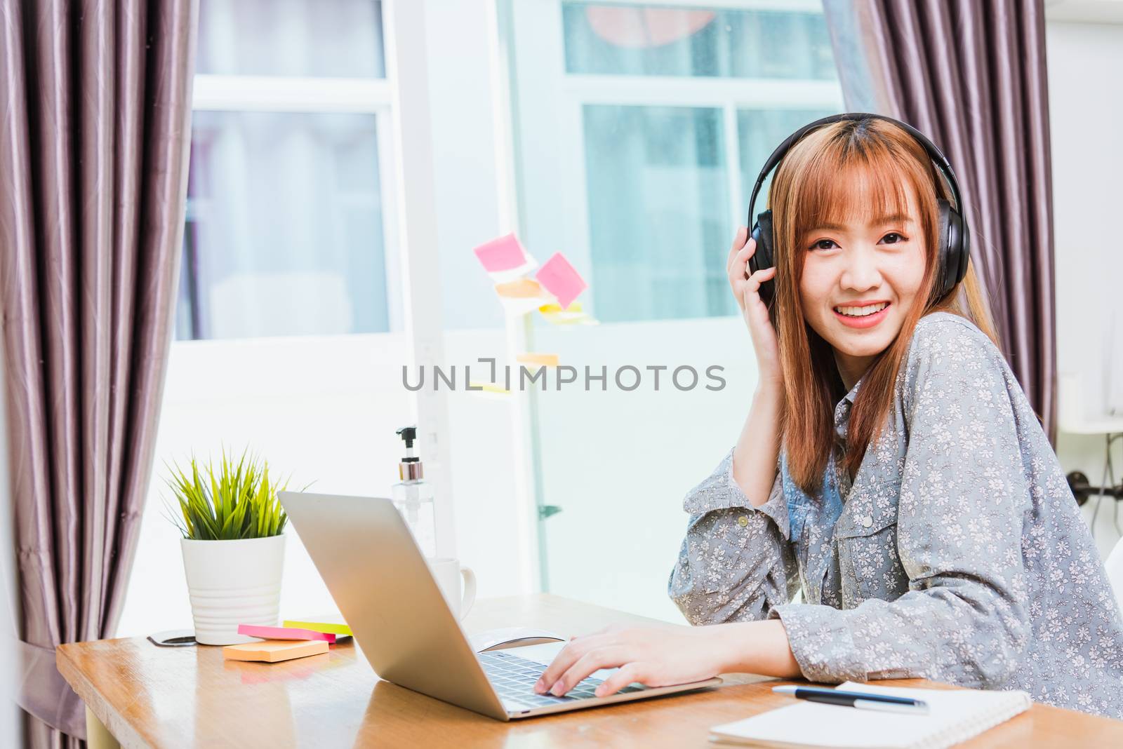 Work from home concept, Happy Asian beautiful young business woman wearing headphone call online conference video call meeting for discussion talking with boos and team together by laptop computer