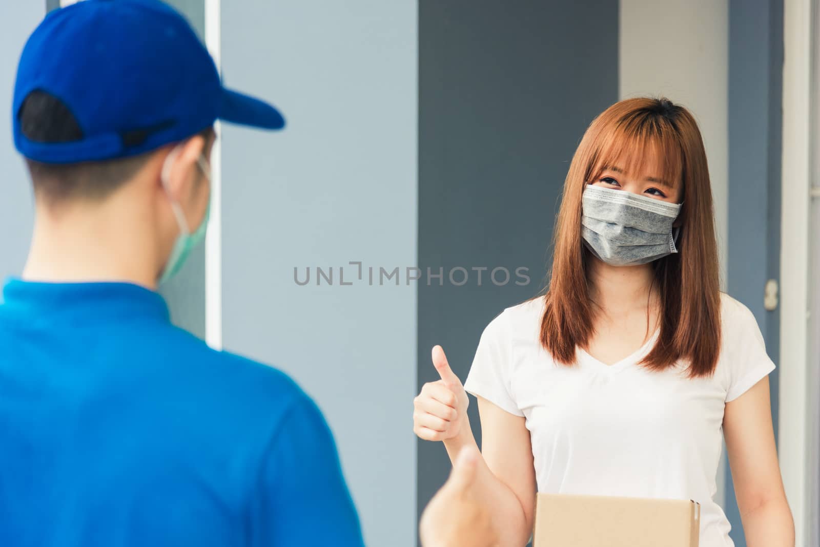 delivery express courier young man giving parcel boxes to woman  by Sorapop