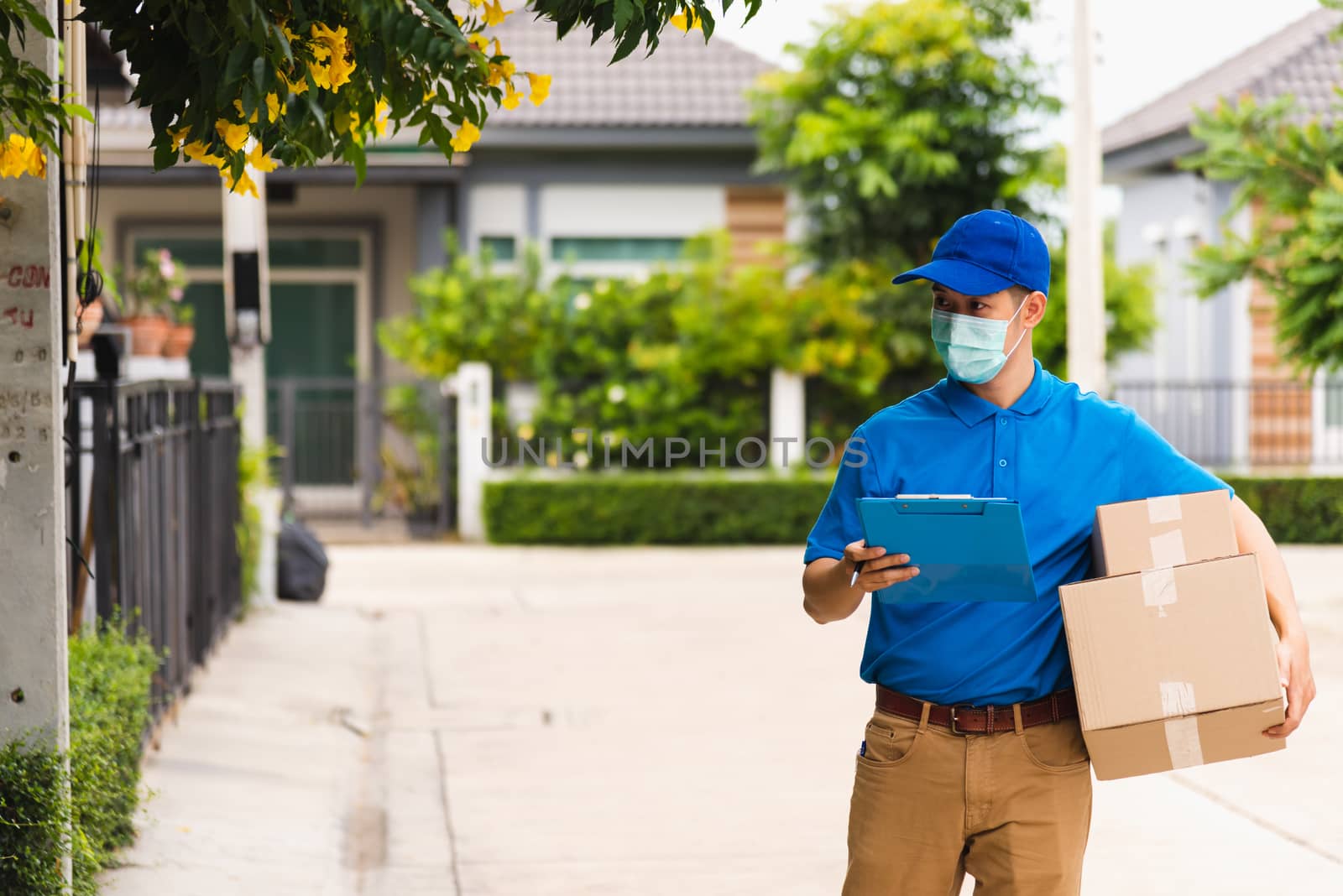 delivery man courier hold parcel post boxes he protective face m by Sorapop