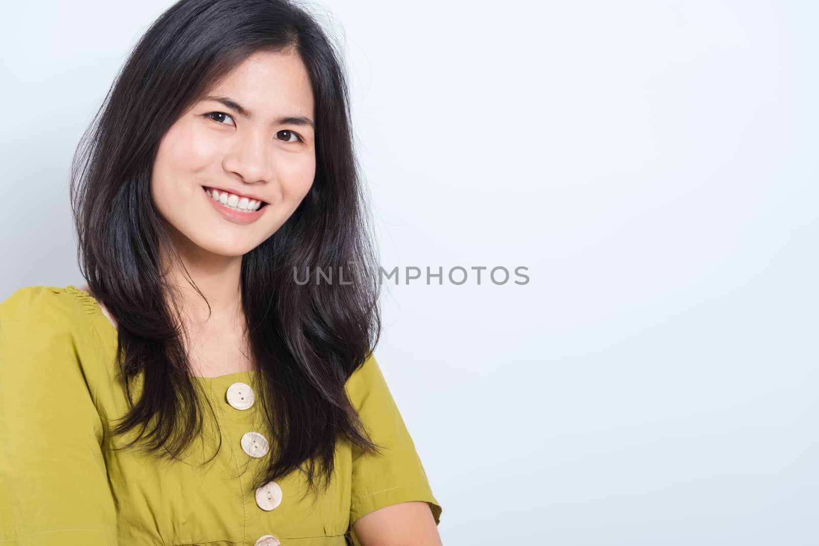 Portrait Asian beautiful young woman standing smile seeing white teeth, She looking at the camera, shoot photo in studio on white background. There was a copy space to put text on the right-hand side.