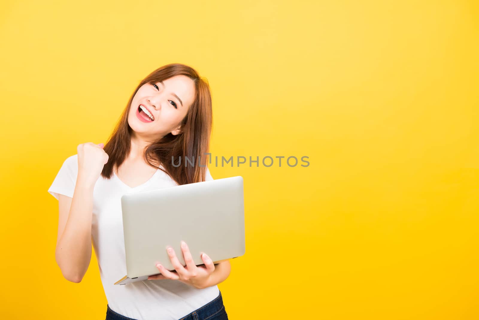 woman teen smile standing wear t-shirt hold laptop computer and  by Sorapop