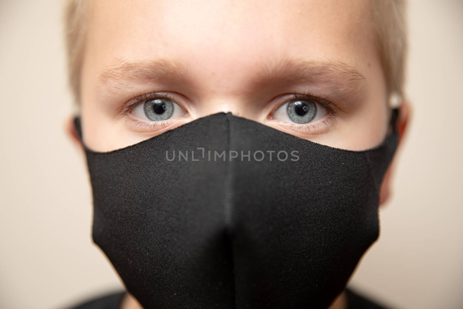 close up shot focused on the eyes of a young boy wearing a face mask