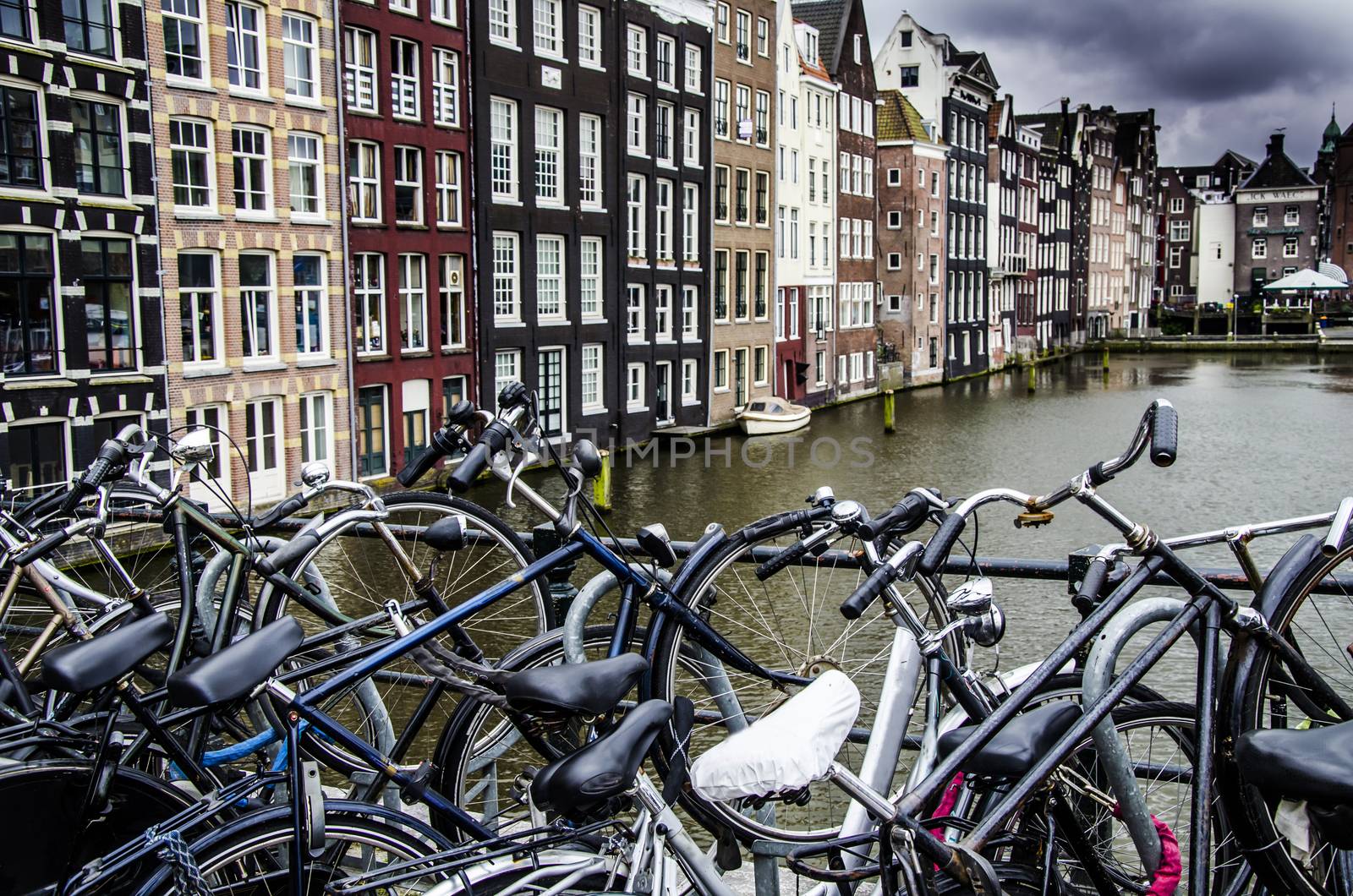 Symbols of amsterdam bicycles and boat moored in one of its cana by MAEKFOTO
