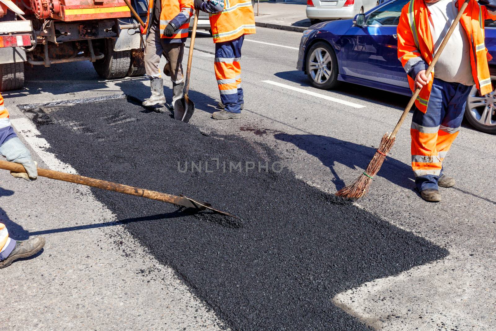 The working team repairs the selected area on the carriageway. by Sergii