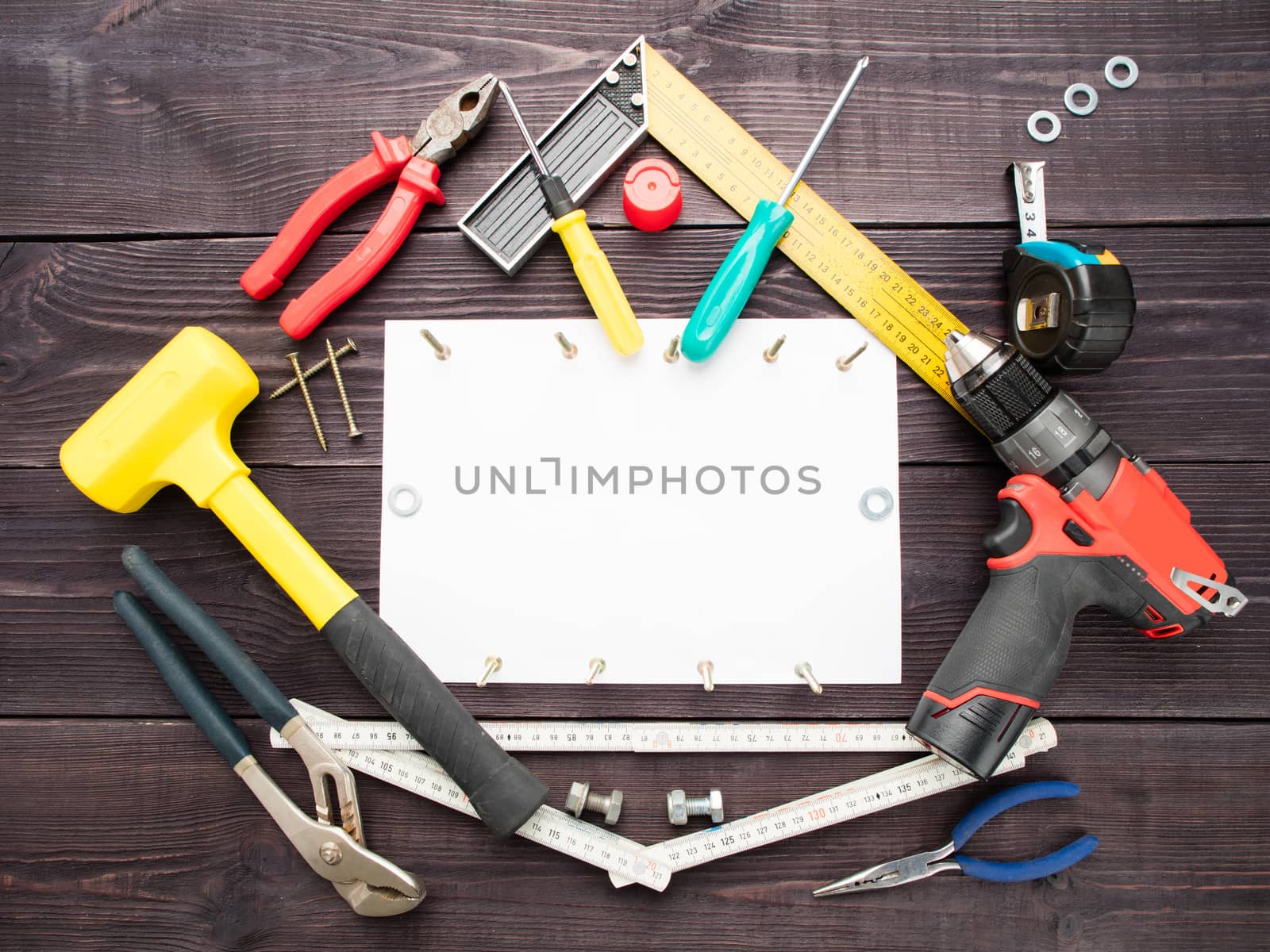 The tool building on the wooden background around the white sheet of paper