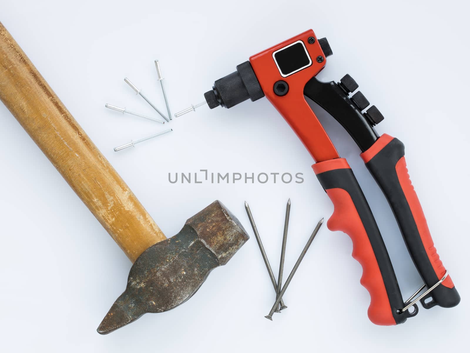 Old hammer and nails against new Rivet Gun and Rivets by Sergii