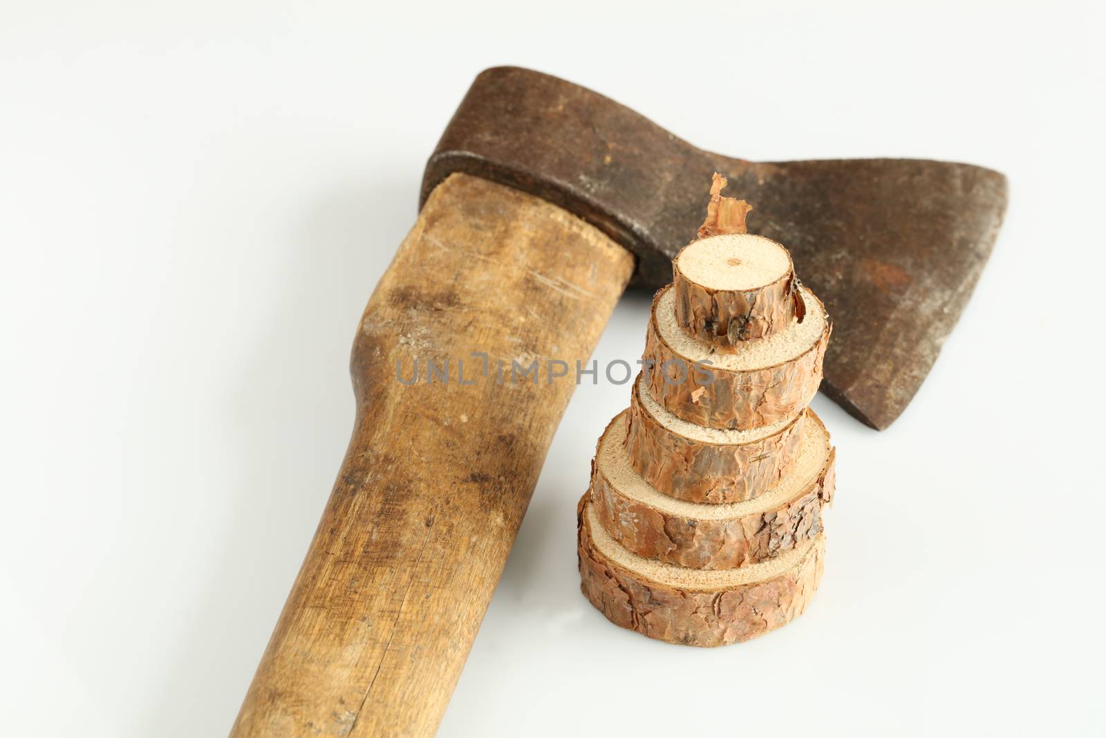 Three rings of a section of a tree trunk against a background of an old ax against a white background