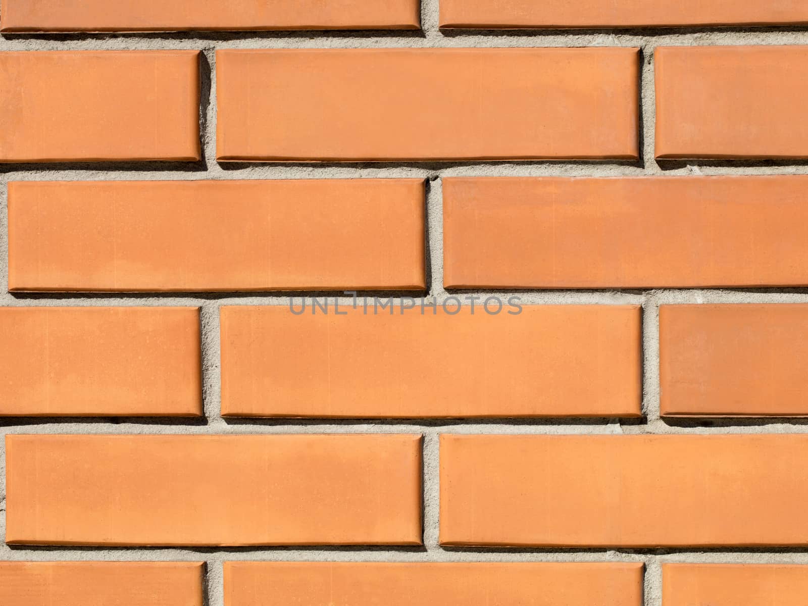 Orange brick wall background close-up on the sunny side