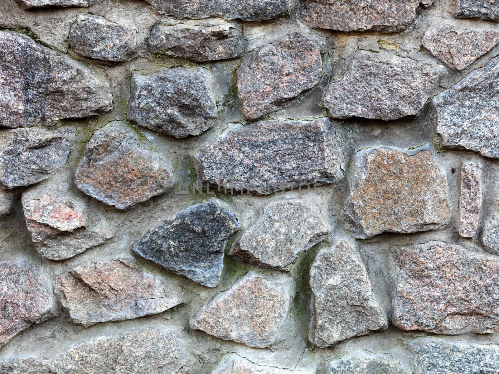 Stone wall from a large granite cobblestone close-up by Sergii