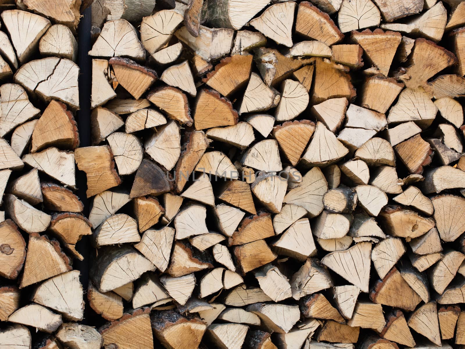 A stack of chopped firewood stacked on top of each other by Sergii