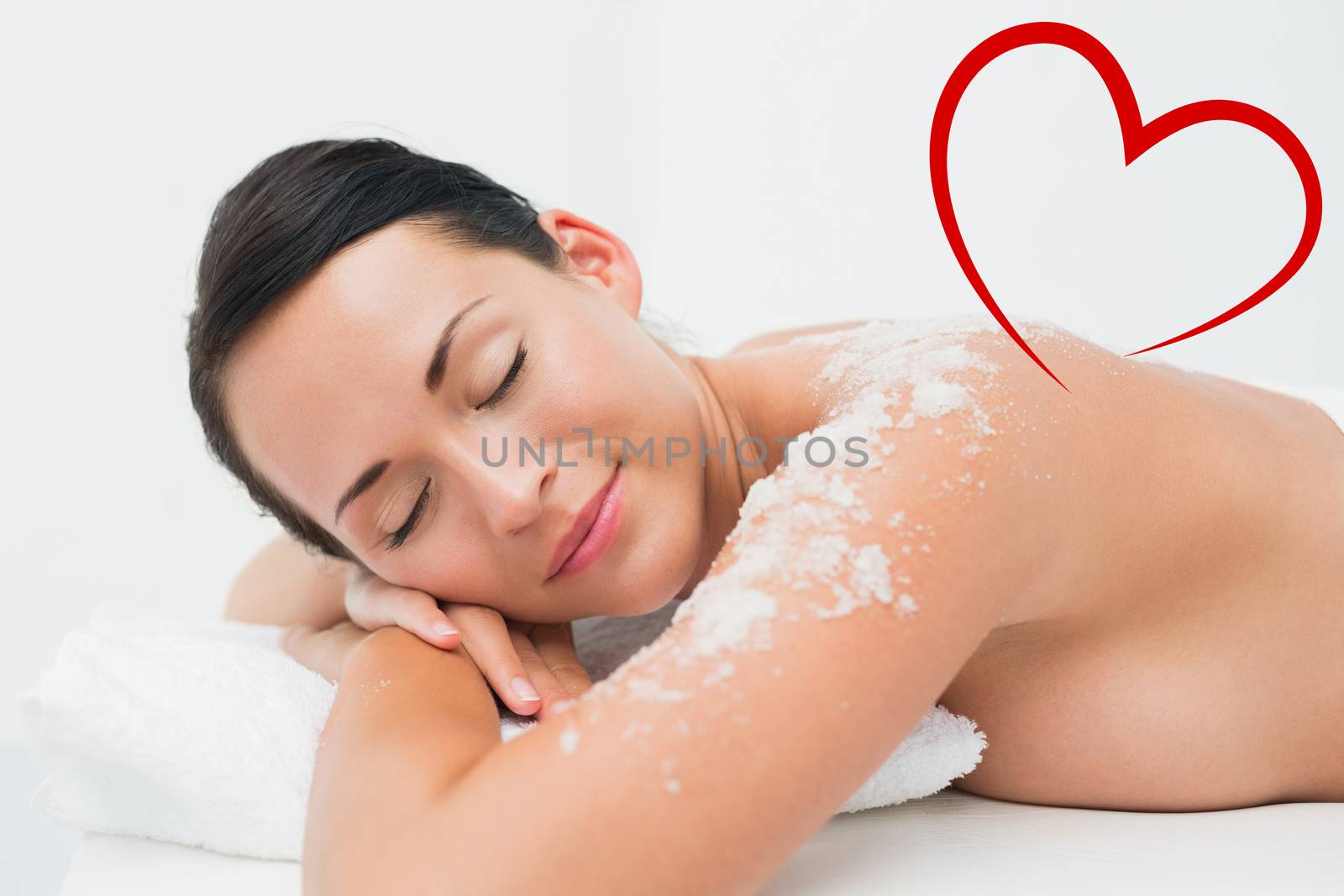 Composite image of peaceful brunette lying with salt scrub on shoulders by Wavebreakmedia