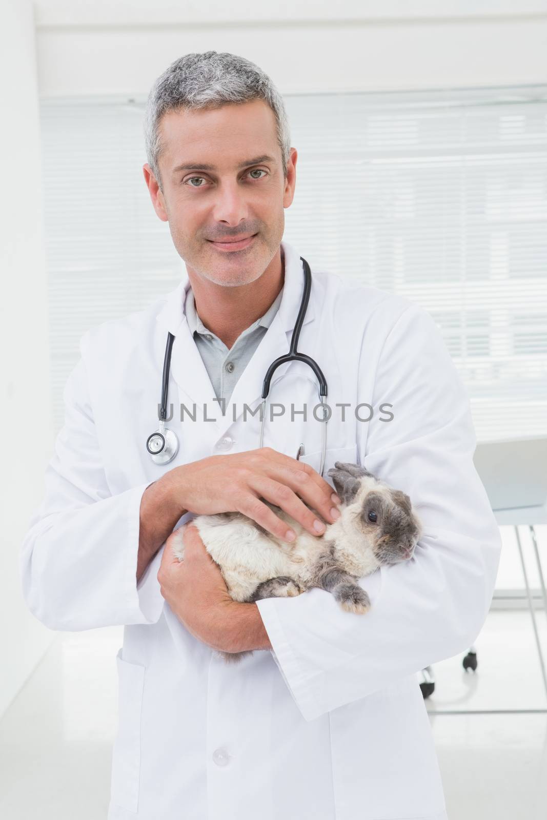 Veterinarian with a rabbit in his arms by Wavebreakmedia