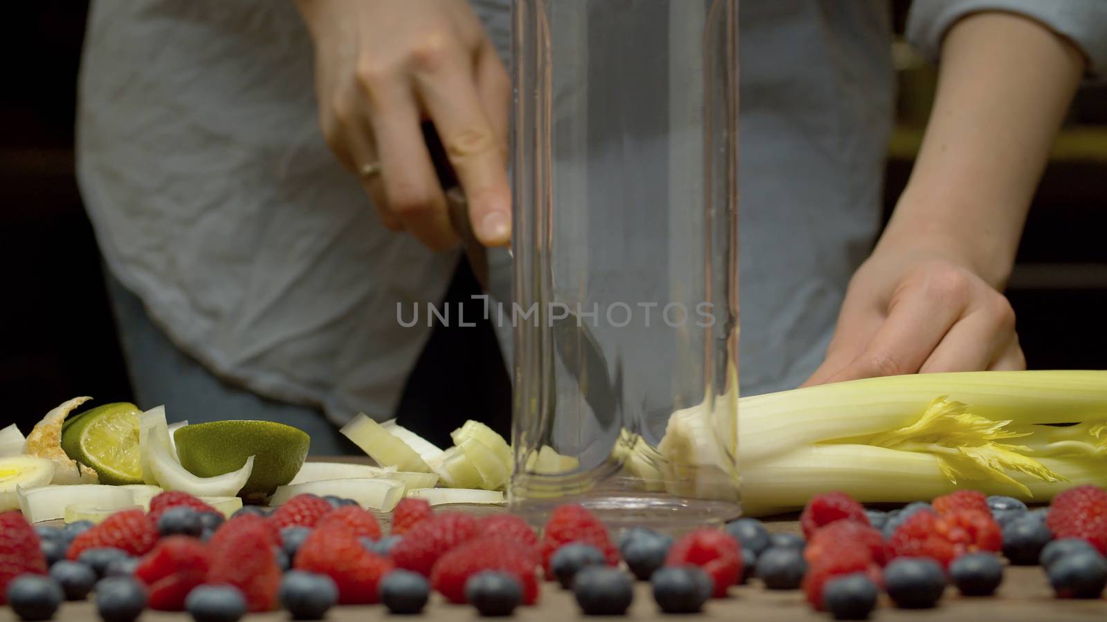 Close up female hands chopping celery. Cooking of smoothies closeup. Healthy lifestyle and eating concept