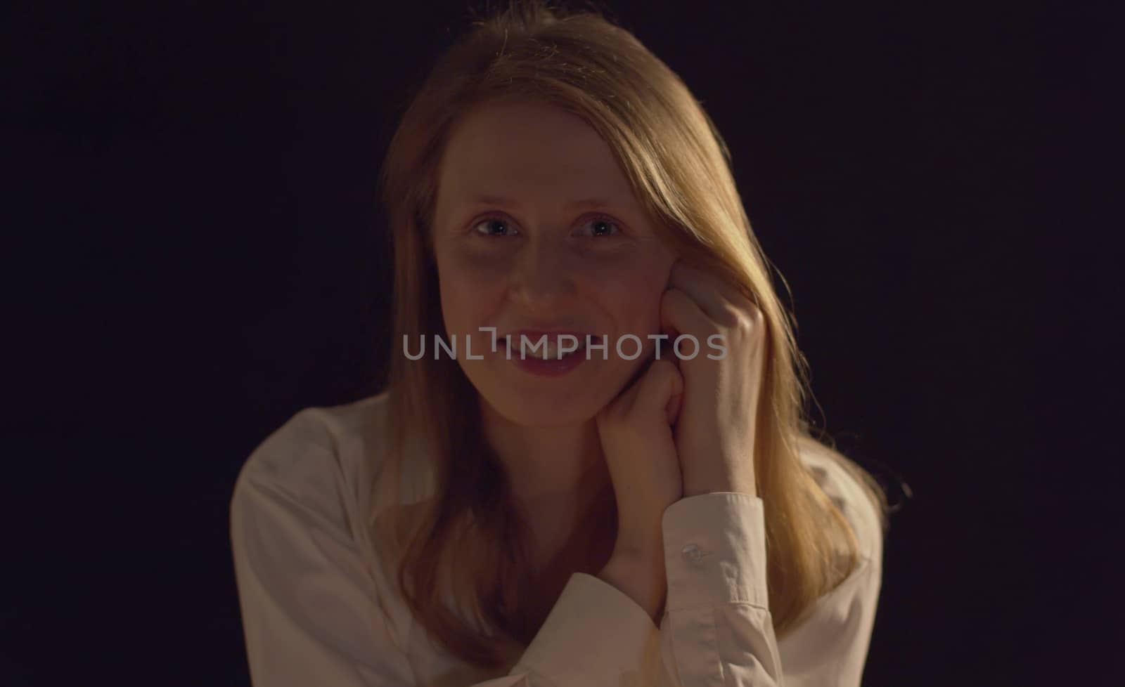 Close up portrait of a young smiling woman on a dark background. Pretty caucasian lady front view