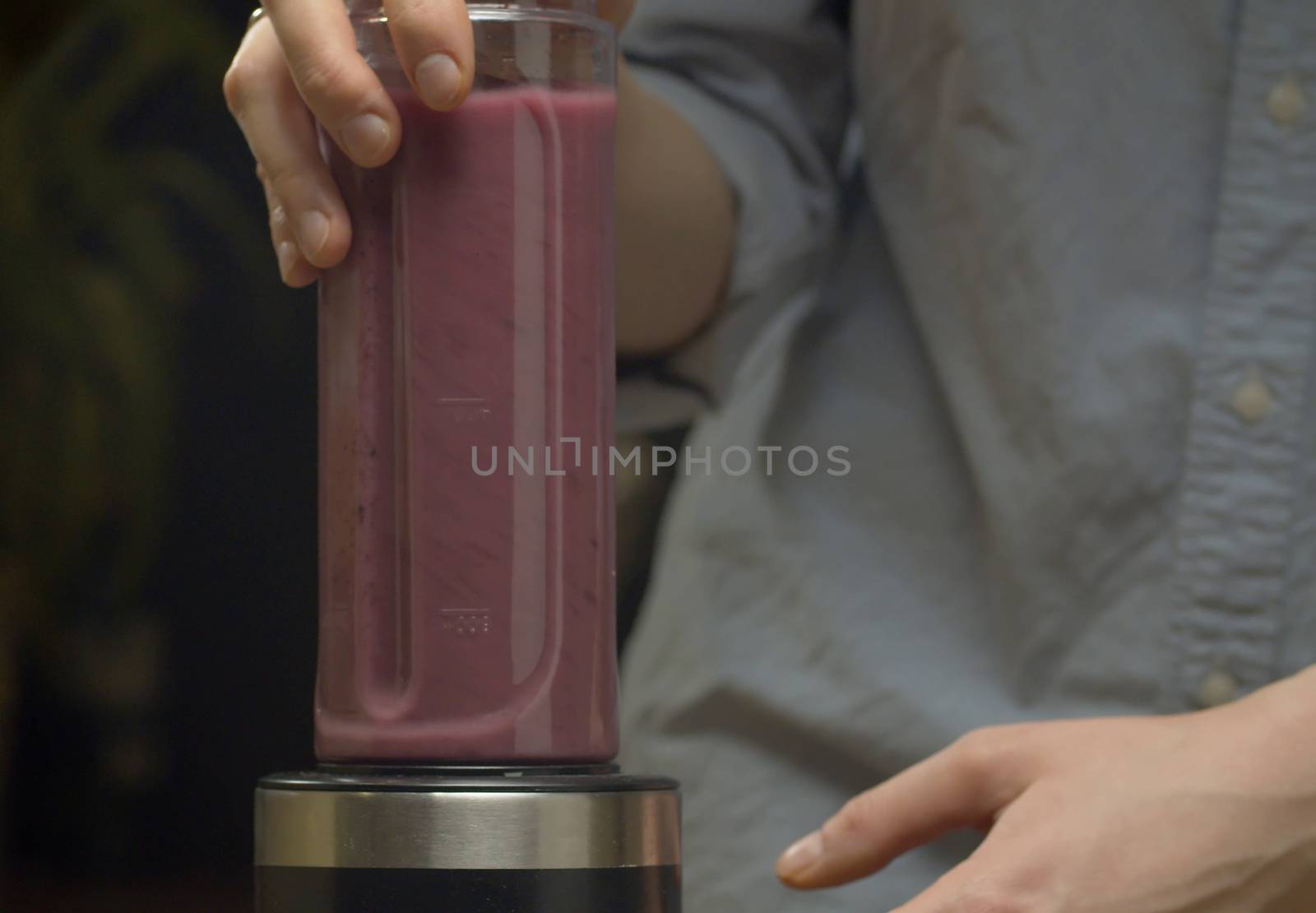 Cooking smoothies in the kitchen. Red banana blackberry smoothie blending in blender. Healthy lifestyle and eating concept