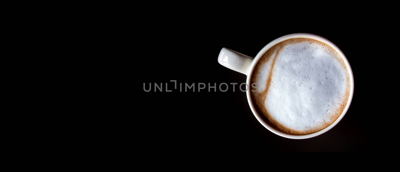 Hot milk coffee and soft froth in white ceramic cup by Satakorn